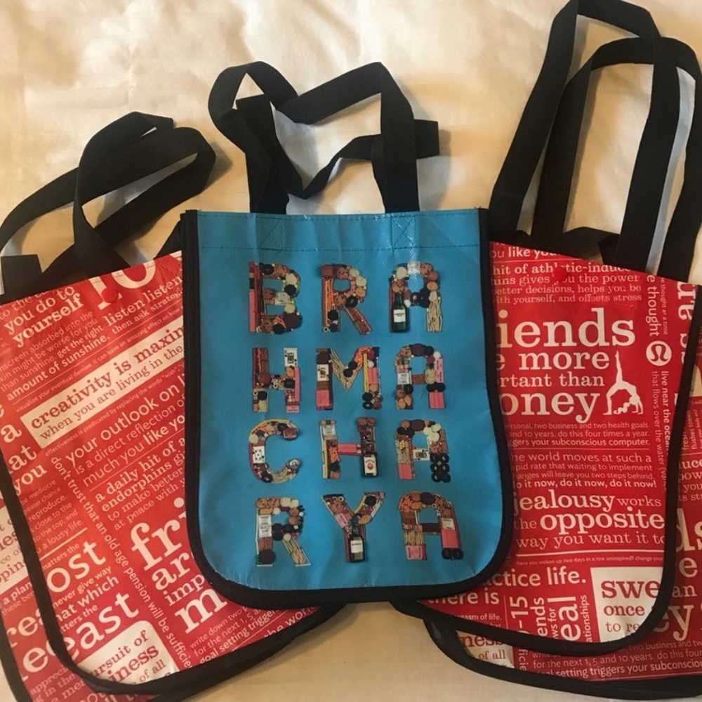 3 Luluemon small shopping bags - 2 red and 1 blue.